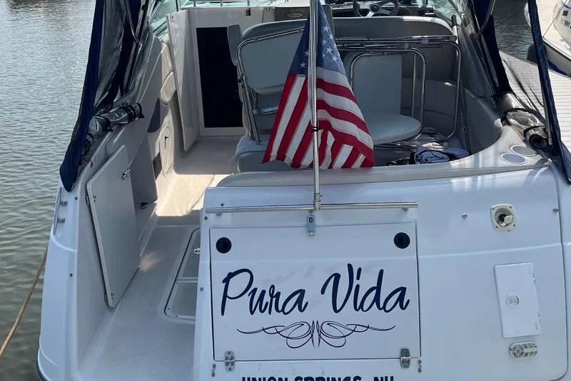 Slide: The Image of 2002 Four Winns 268 Vista boat named "Pura Vida" with American flag, docked. - 3