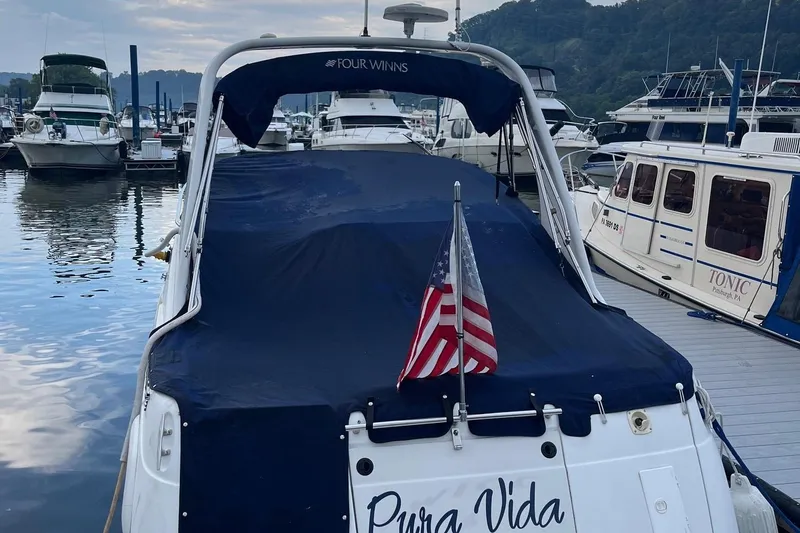 Slide: The Image of 2002 Four Winns 268 Vista boat docked, covered with a blue tarp, American flag displayed. - 5