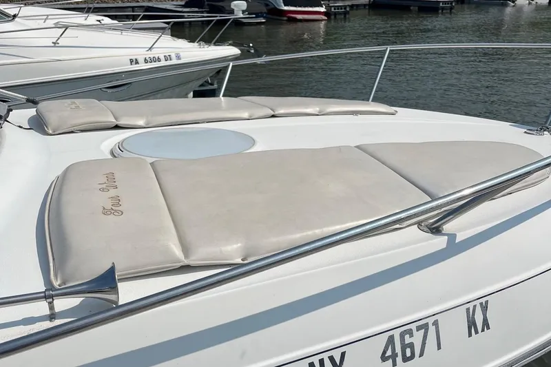 Slide: The Image of 2002 Four Winns 268 Vista boat with cushioned deck, docked at marina. - 6