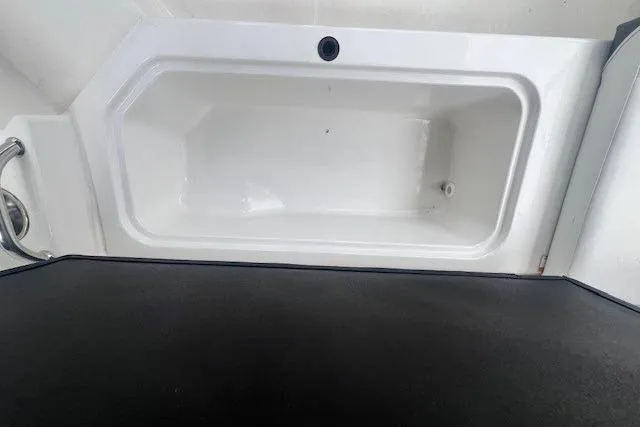 Slide: The Image of 2018 Sea Ray 19 SPX OB boat storage compartment, white interior, black trim. - 7