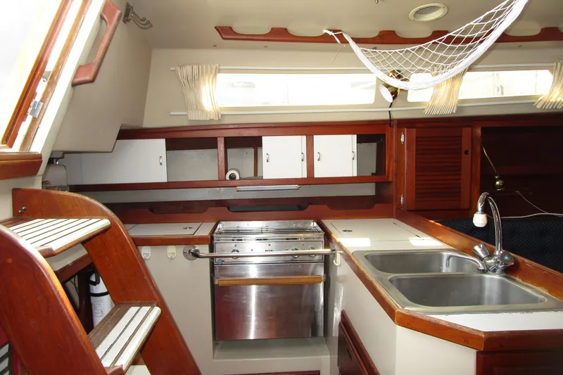 Slide: The Image of Interior of 1989 Catalina 36 sailboat kitchen with wooden cabinetry and stainless steel sink. - 12