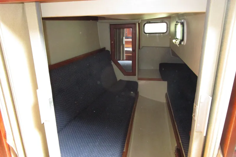 Slide: The Image of Interior cabin of a 1989 Catalina 36 sailboat with blue cushioned seating. - 15