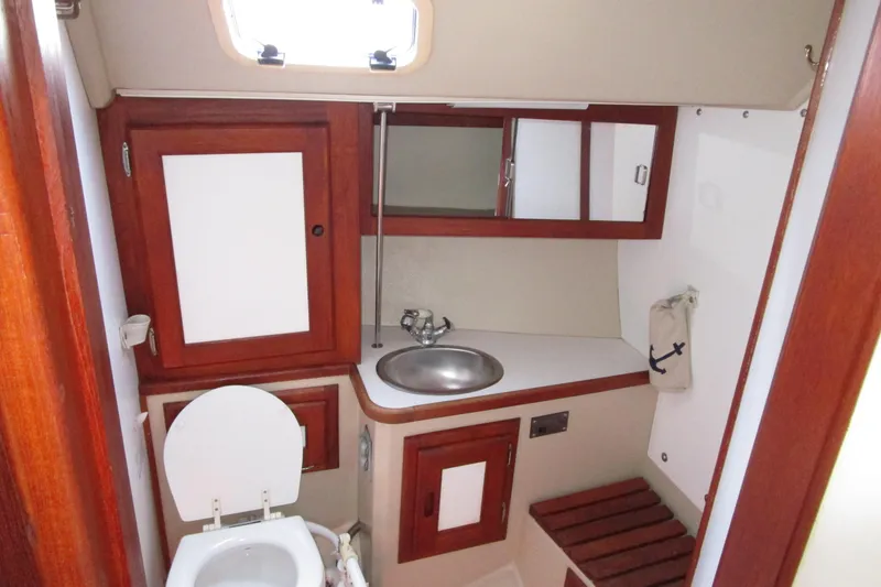 Slide: The Image of 1989 Catalina 36 yacht bathroom with wooden cabinets, sink, and toilet. - 22