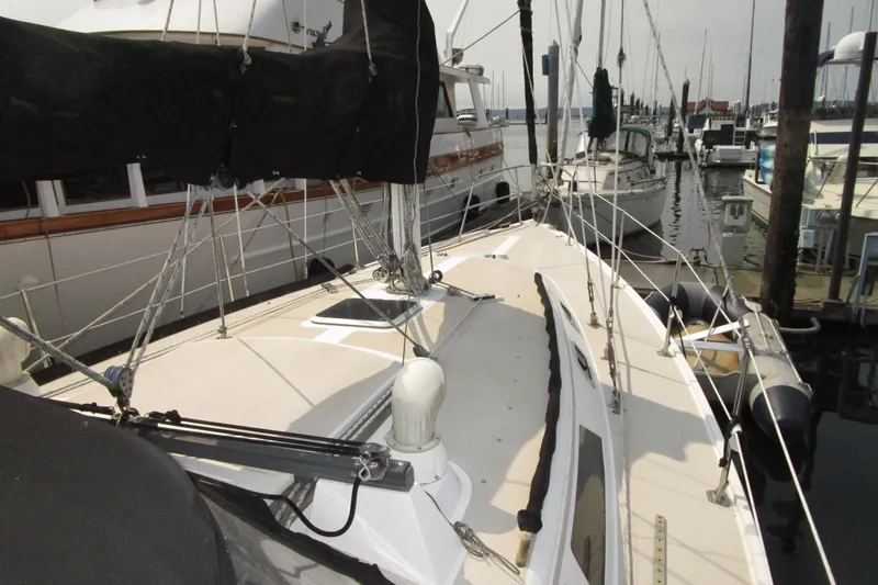 Slide: The Image of 1989 Catalina 36 sailboat docked at marina, showcasing deck and rigging. - 9