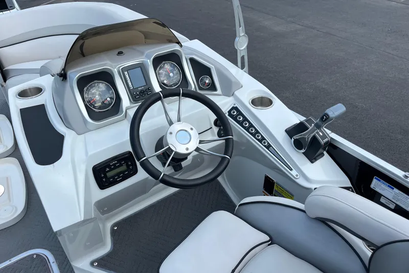 Slide: The Image of 2014 Manitou 23 X-Plode boat dashboard with steering wheel and controls. - 4