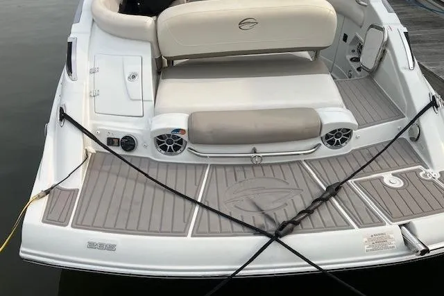 Slide: The Image of 2018 Crownline 285 SS boat rear view with seating and speakers on a dock. - 3
