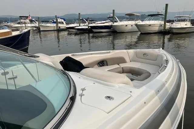 Slide: The Image of 2018 Crownline 285 SS boat docked in marina with other vessels. - 4