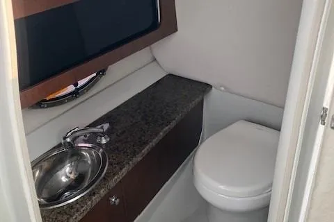 Slide: The Image of 2018 Crownline 285 SS boat bathroom with sink, granite countertop, and toilet. - 6