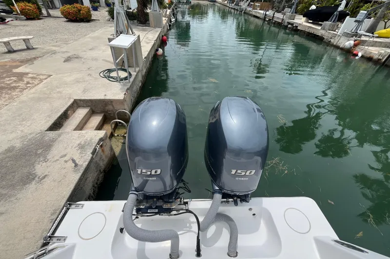 Slide: The Image of 2015 Contender 24 Sport boat with twin Yamaha 150 outboard engines docked in a canal. - 11