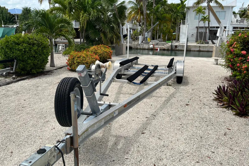 Slide: The Image of Boat trailer for 2015 Contender 24 Sport, parked near tropical canal setting. - 13