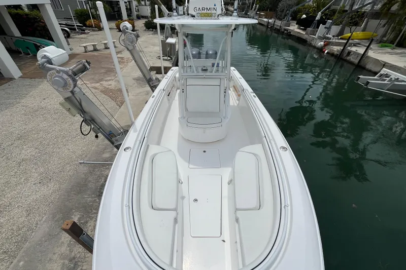Slide: The Image of 2015 Contender 24 Sport boat docked in a canal, featuring a sleek white design. - 3