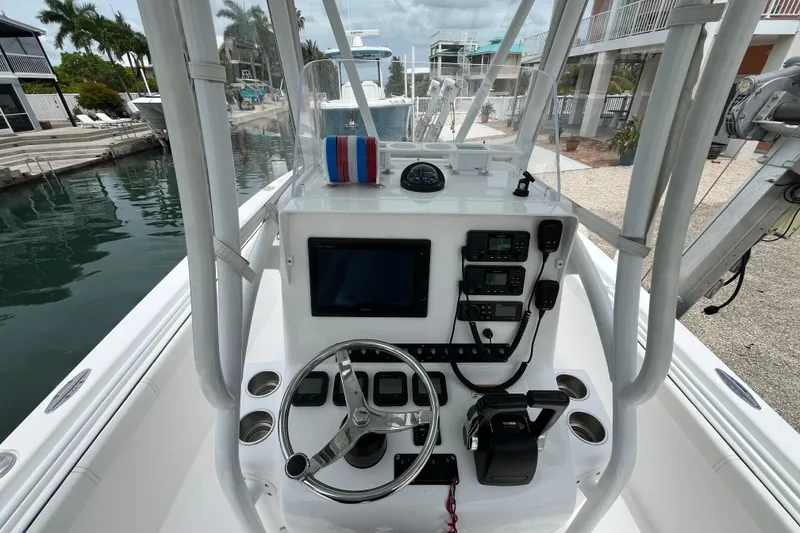 Slide: The Image of 2015 Contender 24 Sport boat console with steering wheel and navigation equipment. - 8