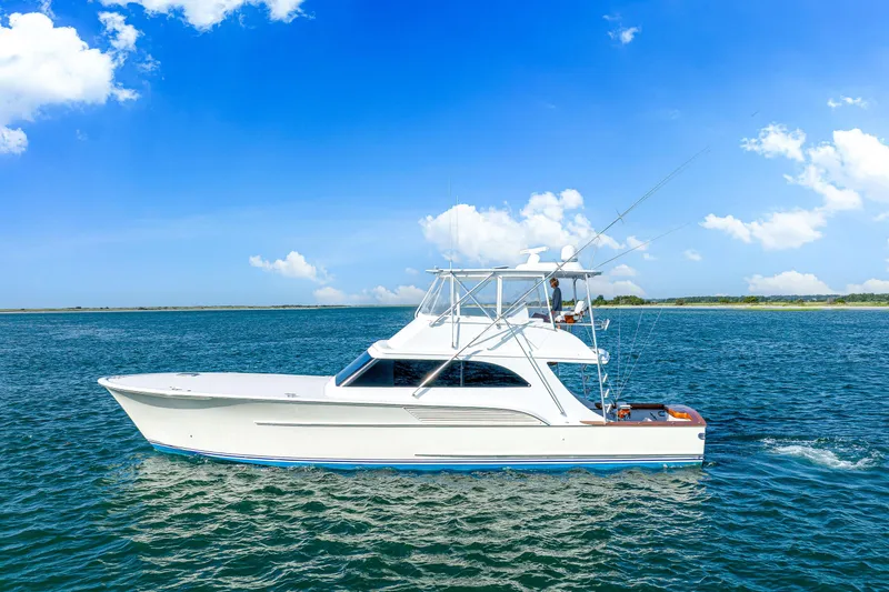 The Image of 2004 Sculley Custom Carolina 58' Sportfish yacht cruising on open water under blue skies. - 0