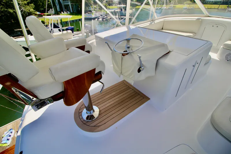 Slide: The Image of Luxurious helm of 2004 Sculley Custom Carolina 58' Sportfish with white seating and wooden accents. - 16
