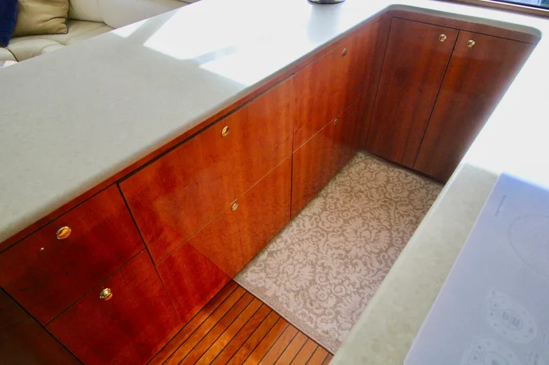 Slide: The Image of Interior of 2004 Sculley Custom Carolina 58' Sportfish with wooden cabinetry and patterned rug. - 32