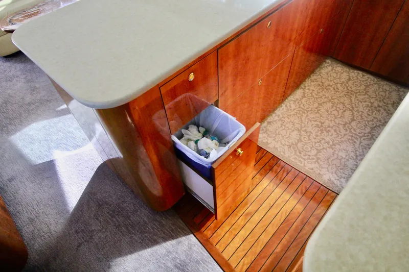 Slide: The Image of Interior of 2004 Sculley Custom Carolina 58' Sportfish with wooden cabinetry and pull-out trash bin. - 35
