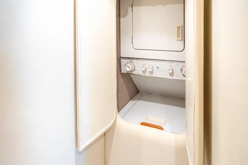 Slide: The Image of Laundry area inside 2004 Sculley Custom Carolina 58' Sportfish yacht, featuring a compact washer-dryer. - 57