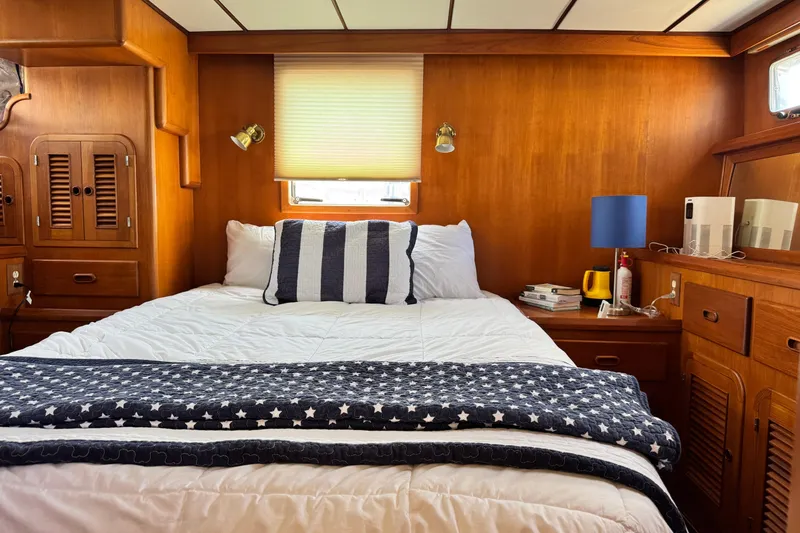 Slide: The Image of Cozy bedroom interior of 1999 Heritage East Sundeck 36 yacht with wooden paneling and nautical decor. - 13
