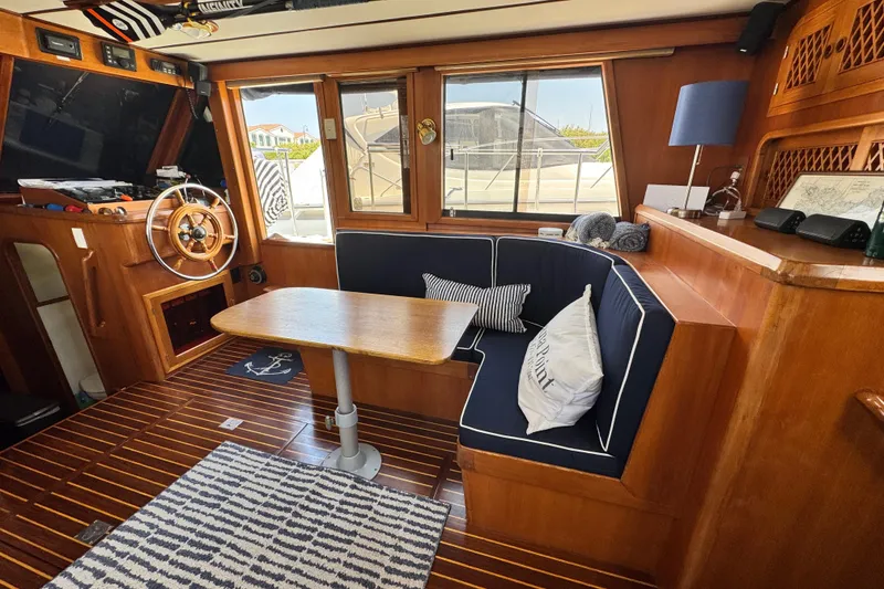 Slide: The Image of Interior of 1999 Heritage East Sundeck 36 with wooden helm, seating, and nautical decor. - 15