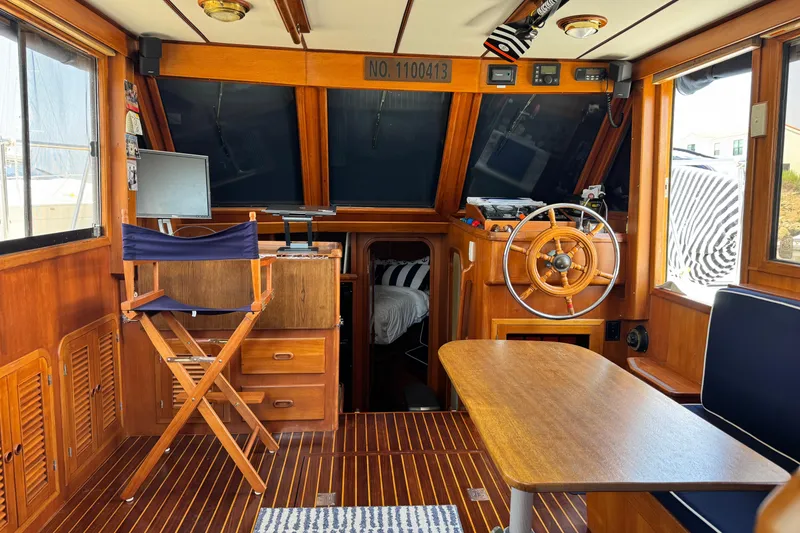 Slide: The Image of Interior of 1999 Heritage East Sundeck 36 with wooden helm, table, and seating. - 16