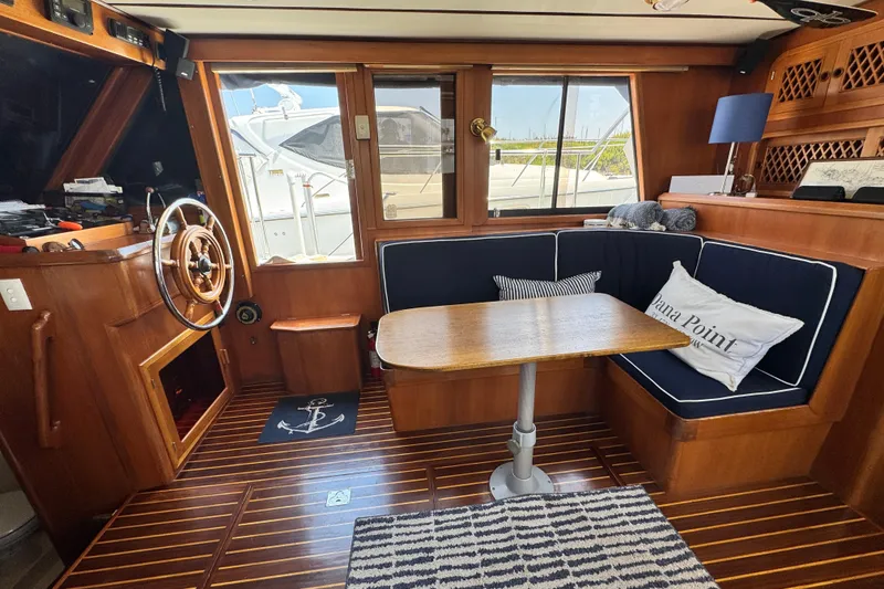 Slide: The Image of Interior of 1999 Heritage East Sundeck 36 yacht with wooden helm and cozy seating area. - 18