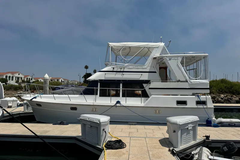 Slide: The Image of 1999 Heritage East Sundeck 36 yacht docked at marina under clear sky. - 2