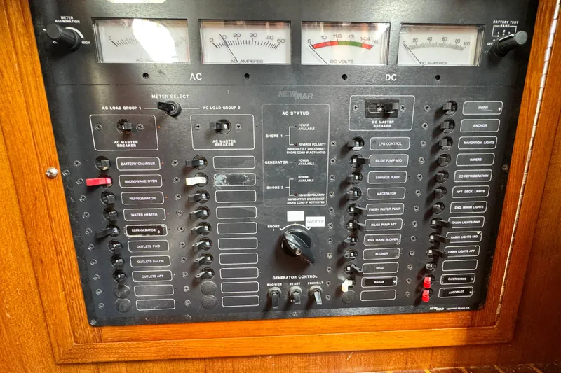 Slide: The Image of Electrical control panel of a 1999 Heritage East Sundeck 36 boat, featuring AC and DC switches. - 21