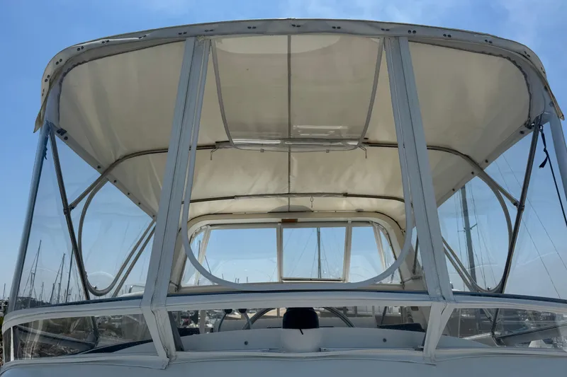 Slide: The Image of 1999 Heritage East Sundeck 36 boat canopy with clear panels and blue sky background. - 36