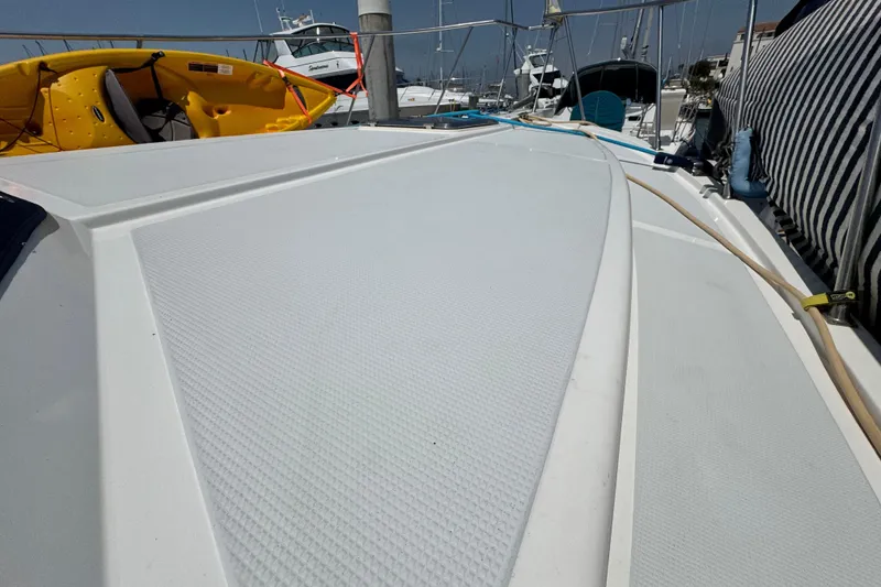 Slide: The Image of 1999 Heritage East Sundeck 36 boat deck with kayaks and marina background. - 37