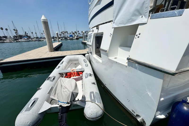 Slide: The Image of Inflatable dinghy moored beside a 1999 Heritage East Sundeck 36 yacht at a marina. - 38