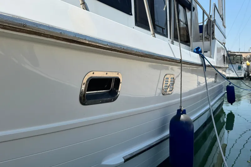 Slide: The Image of 1999 Heritage East Sundeck 36 yacht side view with blue fenders in marina. - 42