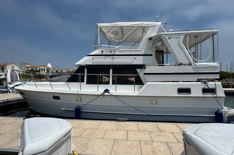 Slide: The Image of 1999 Heritage East Sundeck 36 yacht docked at marina under clear sky. - 5