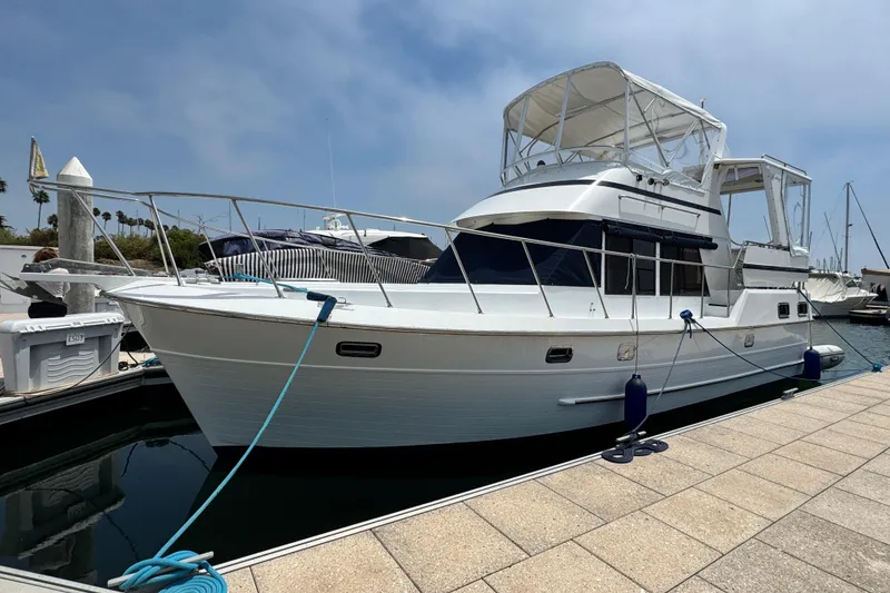 Slide: The Image of 1999 Heritage East Sundeck 36 yacht docked at marina under clear sky. - 6