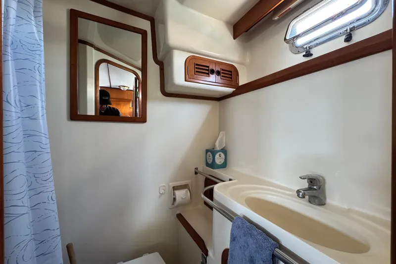 Slide: The Image of Bathroom interior of 1999 Heritage East Sundeck 36 yacht, featuring sink and mirror. - 8