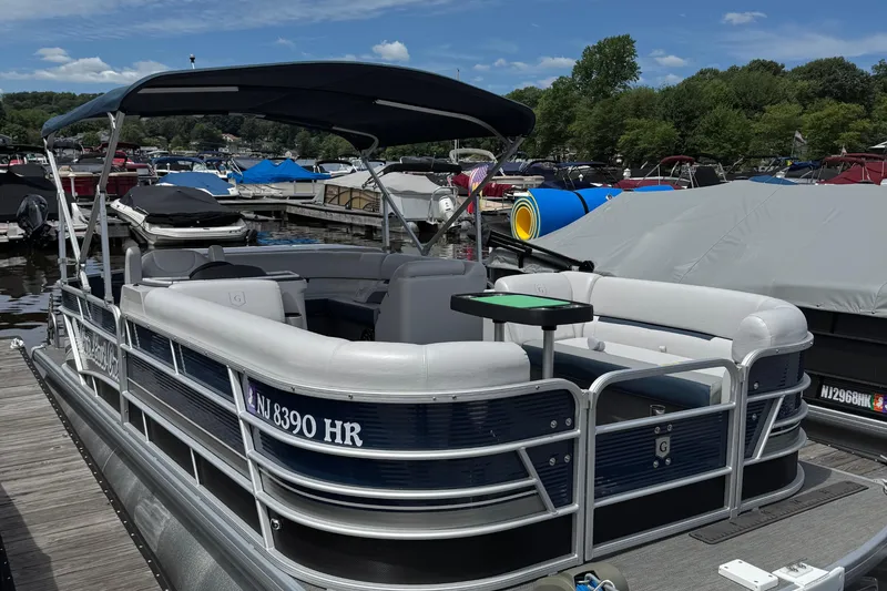 The Image of 2022 Godfrey Sweetwater 2186 C pontoon boat docked at marina under blue sky. - 0