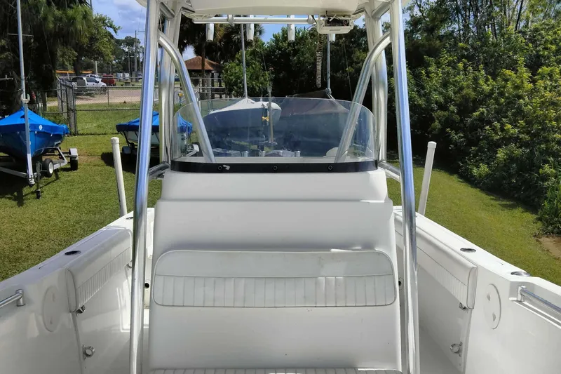 Slide: The Image of 2017 Release 208RX boat interior with console and seating, parked on grass. - 21