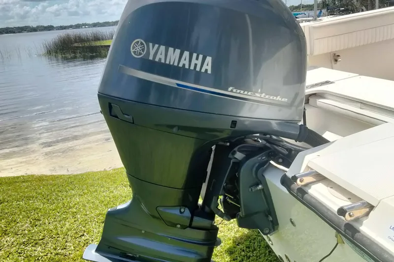 Slide: The Image of Yamaha four-stroke outboard motor on a boat, near a serene lakeside setting. - 26