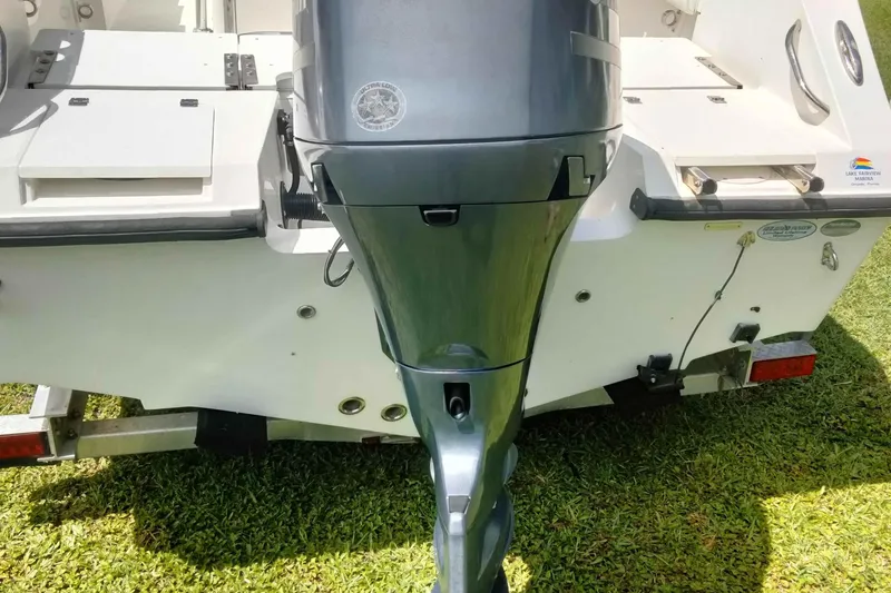 Slide: The Image of Outboard motor on a 2017 Release 208RX boat, parked on grass. - 27