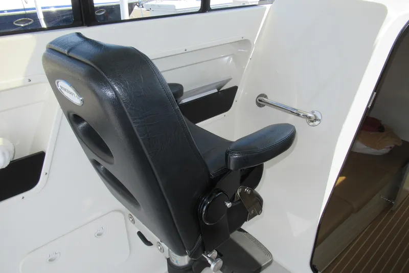 Slide: The Image of 2017 Ribcraft Express 32 interior with black captain's chair and white cabin. - 11