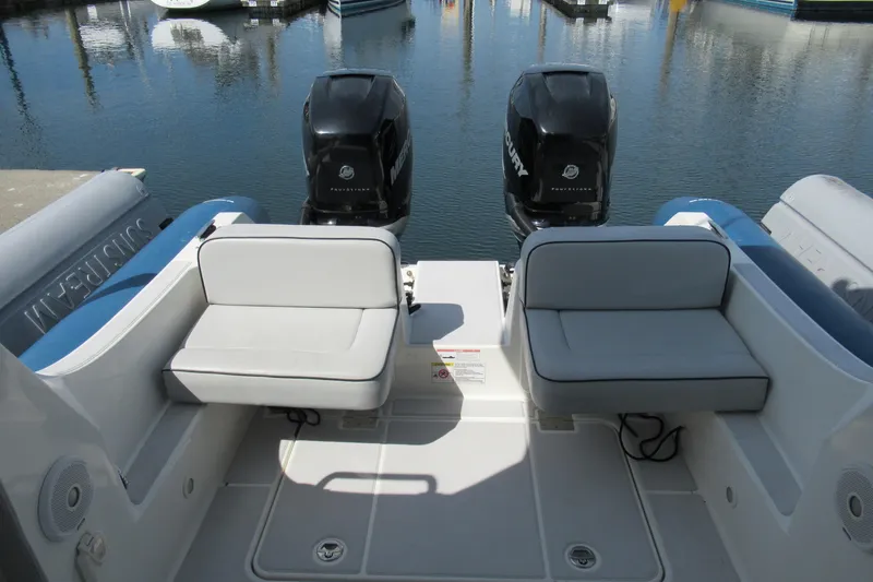 Slide: The Image of 2017 Ribcraft Express 32 boat interior with dual Mercury outboard engines at a marina. - 16