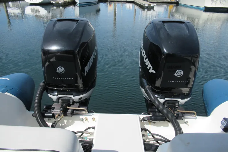 Slide: The Image of Twin Mercury outboard engines on a 2017 Ribcraft Express 32 boat at a marina. - 17