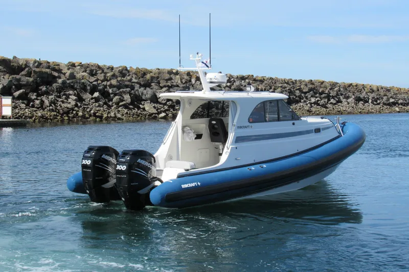 Slide: The Image of 2017 Ribcraft Express 32 boat with dual Mercury engines in a harbor setting. - 3