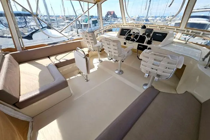 Slide: The Image of 2007 Mainship 34 Trawler interior with helm, seating, and marina view. - 5