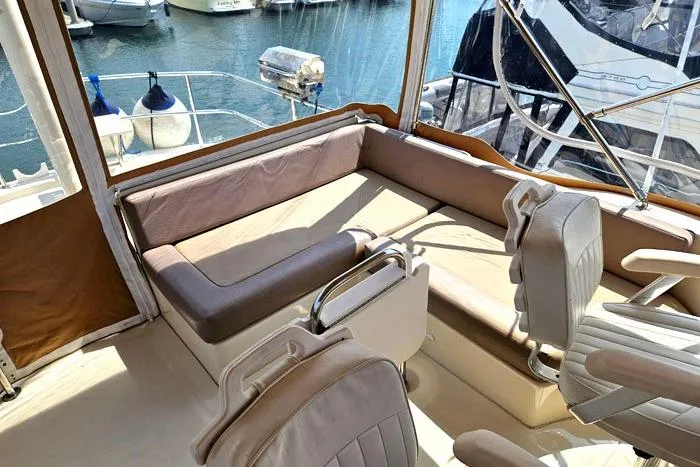 Slide: The Image of 2007 Mainship 34 Trawler interior with seating, docked at marina. - 6