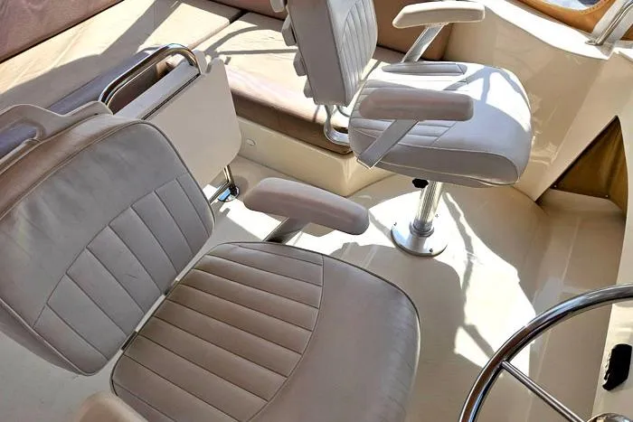 Slide: The Image of 2007 Mainship 34 Trawler helm with two white cushioned captain chairs. - 7