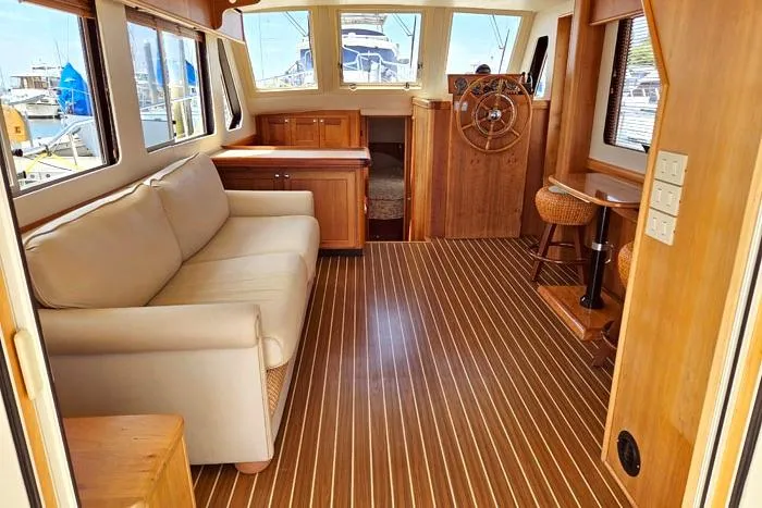 Slide: The Image of Interior of 2007 Mainship 34 Trawler with wooden flooring and beige sofa. - 9
