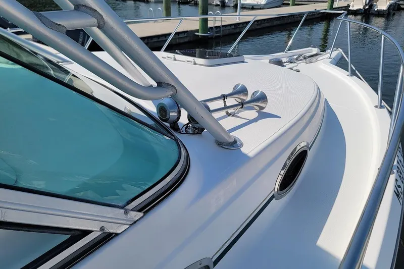 Slide: The Image of 2000 Stamas 310 Express boat deck with horn and railing, docked at marina. - 12