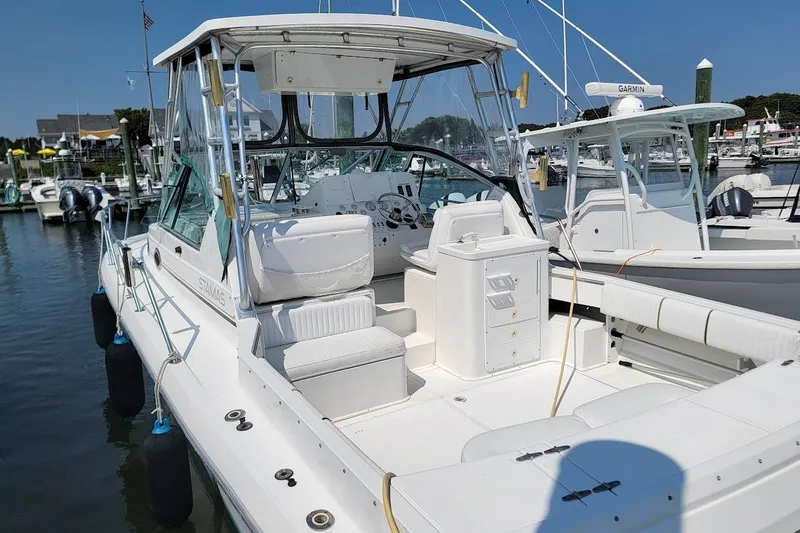 Slide: The Image of 2000 Stamas 310 Express boat docked at marina, featuring spacious seating and modern equipment. - 14