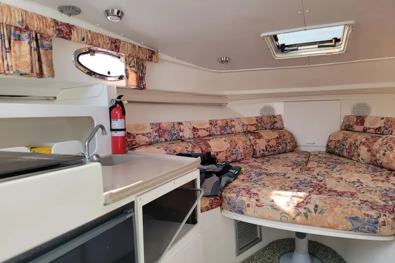 Slide: The Image of Interior of 2000 Stamas 310 Express boat with patterned seating and compact kitchenette. - 17