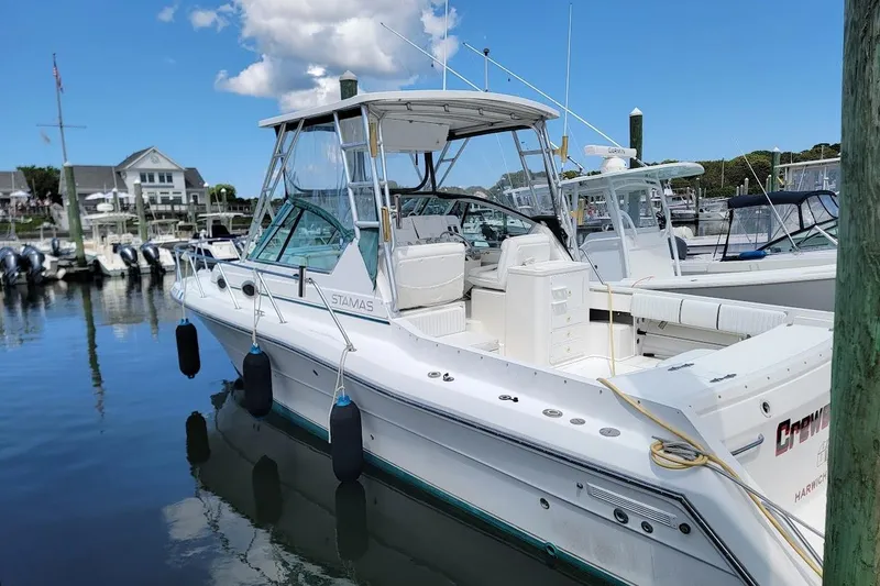 Slide: The Image of 2000 Stamas 310 Express boat docked at marina under clear blue sky. - 24